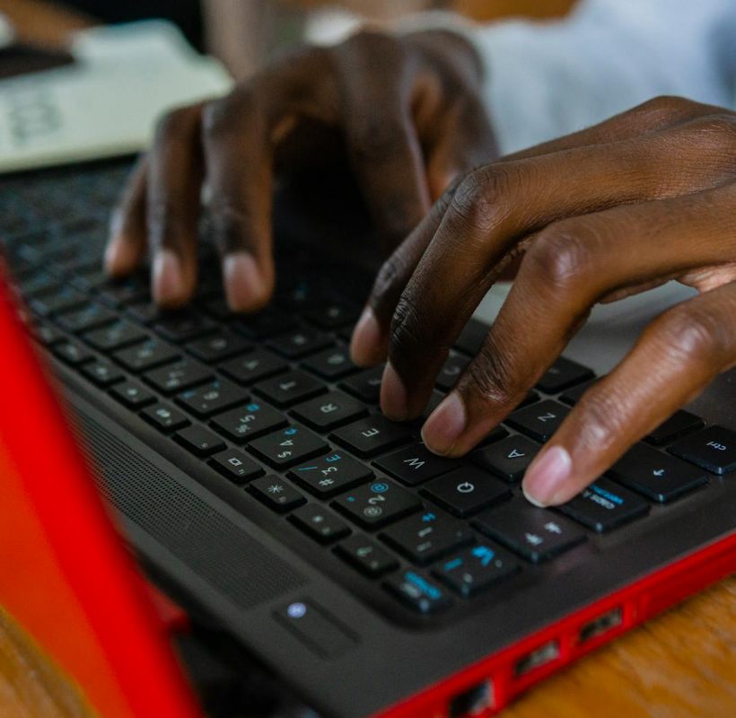 Person Using Black and Red Laptop Computer